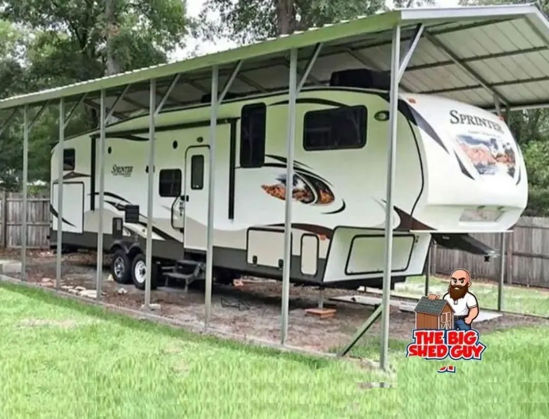 RV parked under a metal carport in a grassy yard.