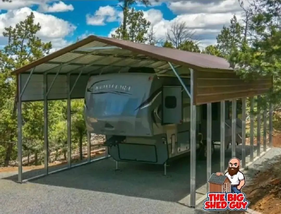 RV under a brown metal carport. Gray RV parked on gravel with trees and blue sky background.