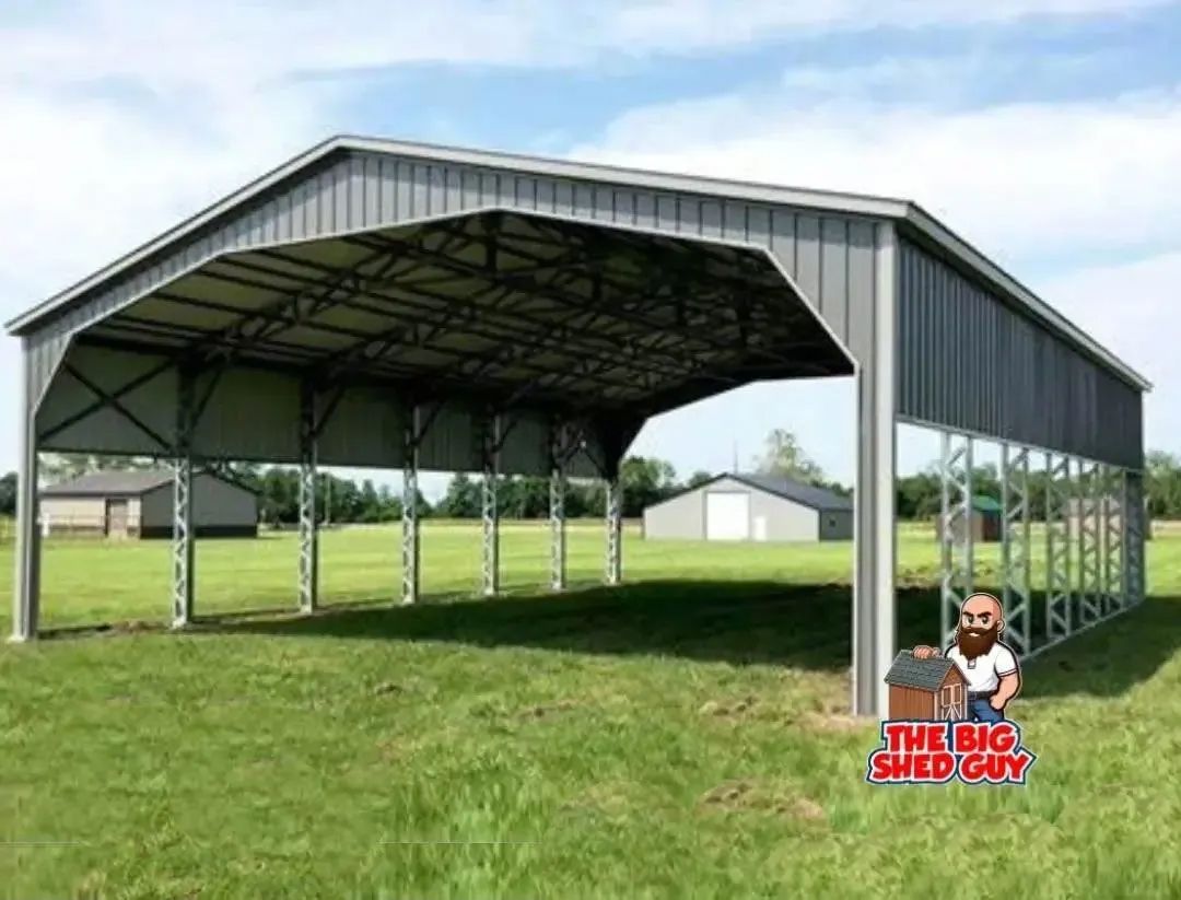 Gray metal carport on a grassy field. A man with a beard stands near the corner.