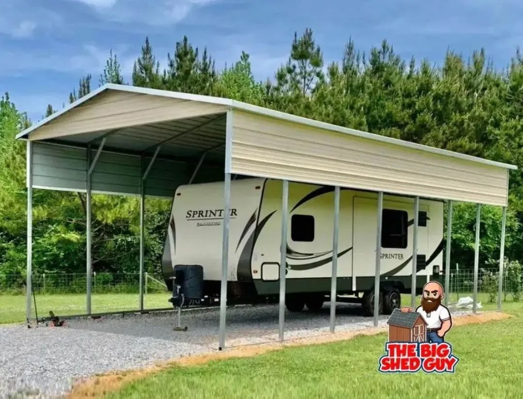 Carport sheltering a camper on a gravel driveway, surrounded by grass and trees.