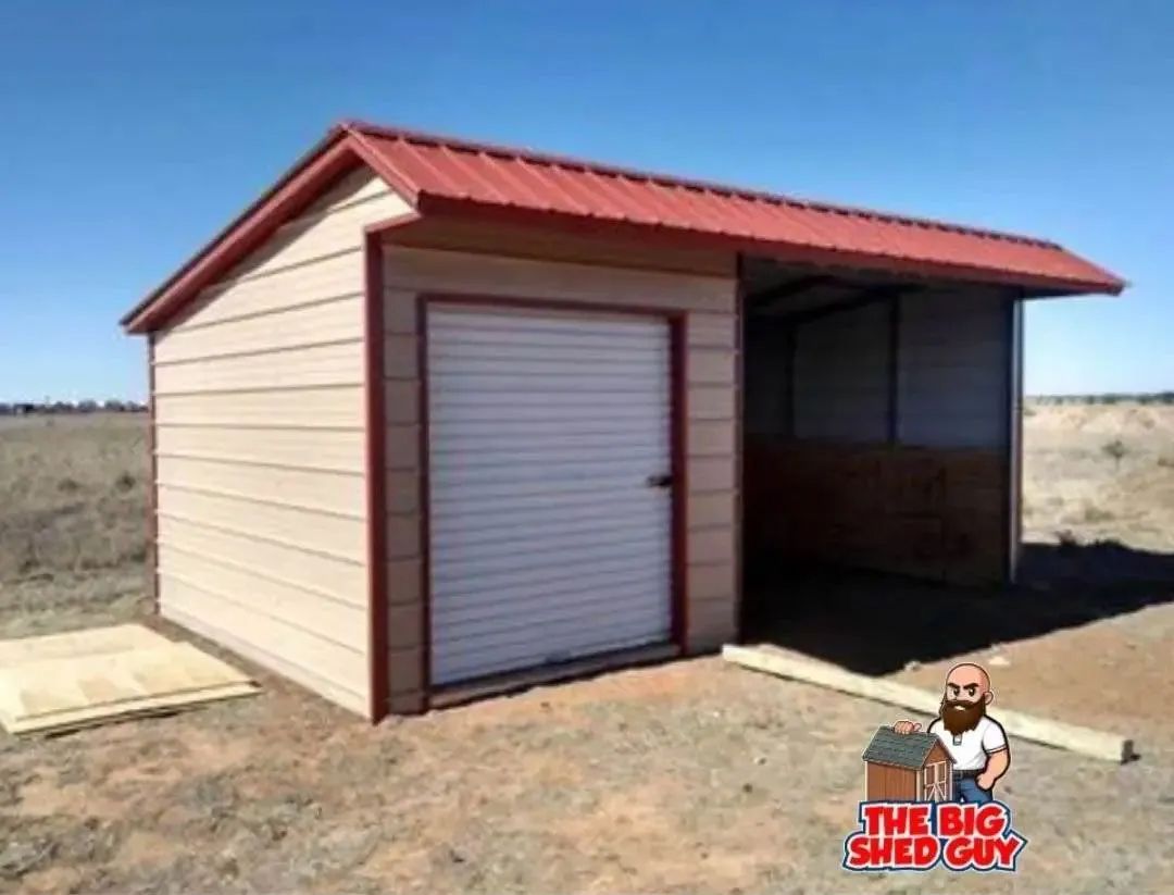Tan shed with red roof and trim, roll-up door, and open-sided section. Set in a field under a blue sky.