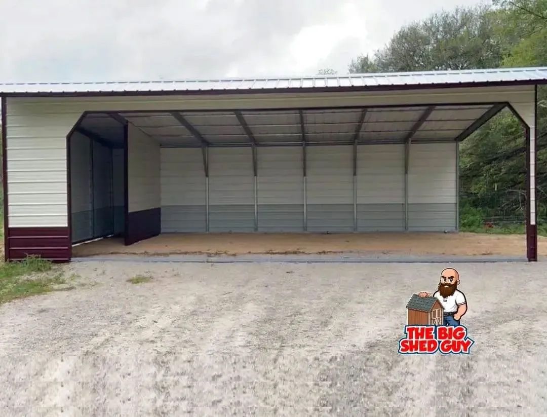 Tan and maroon metal carport shelter in a gravel area. The shelter has an open front.