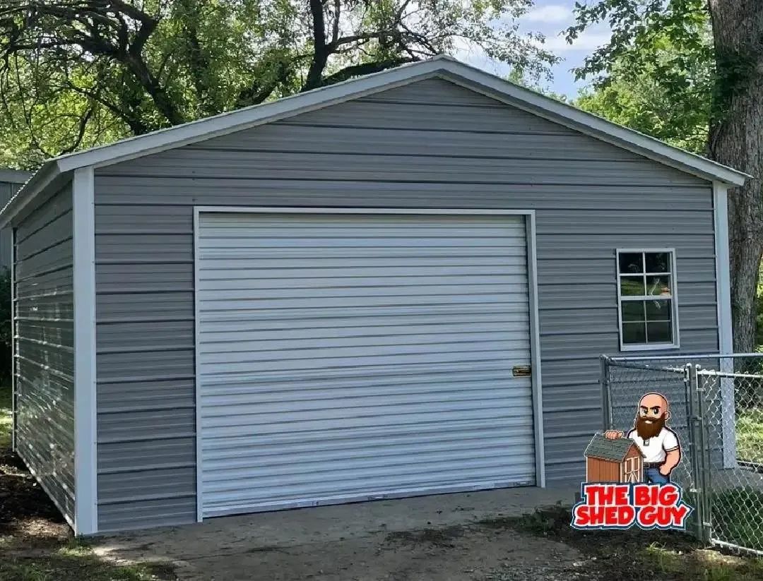 Gray metal shed with a roll-up door and a small window.