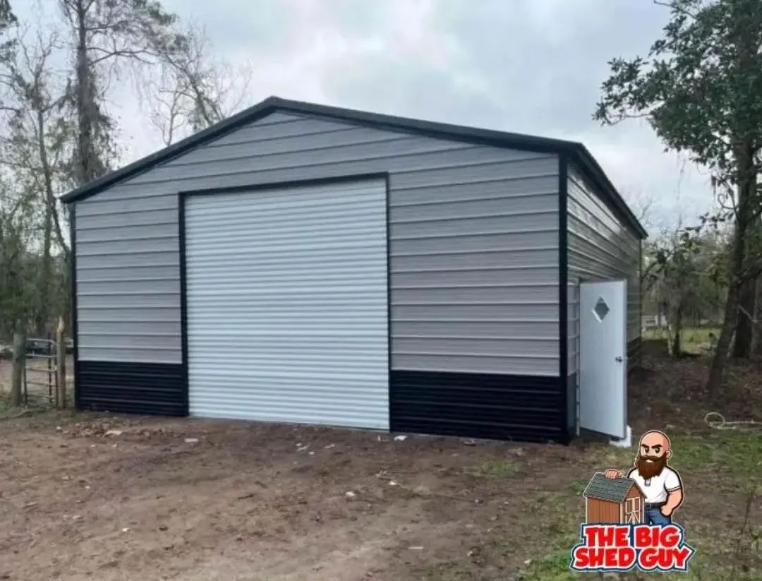 Metal shed with gray and black siding, roll-up door, and white door.