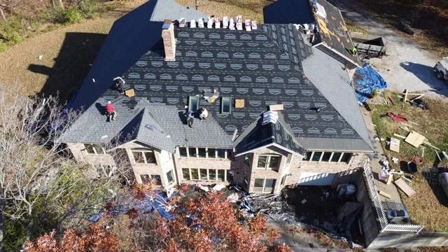 Aerial view of a house roof with scattered debris and damage, likely after a storm or repairs