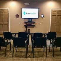 Empty waiting room with chairs facing a TV.