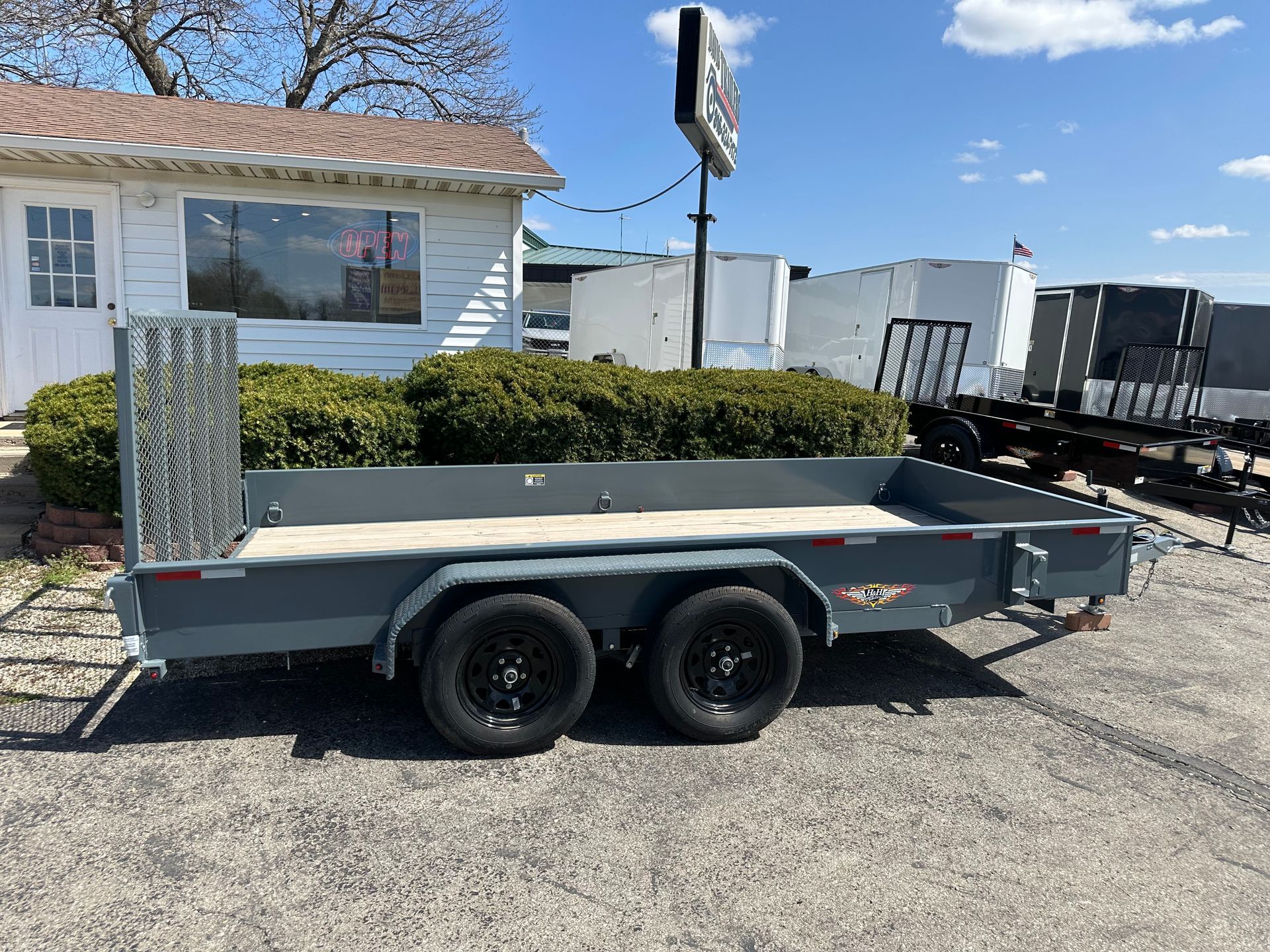 A trailer is sitting on top of a lush green field.
