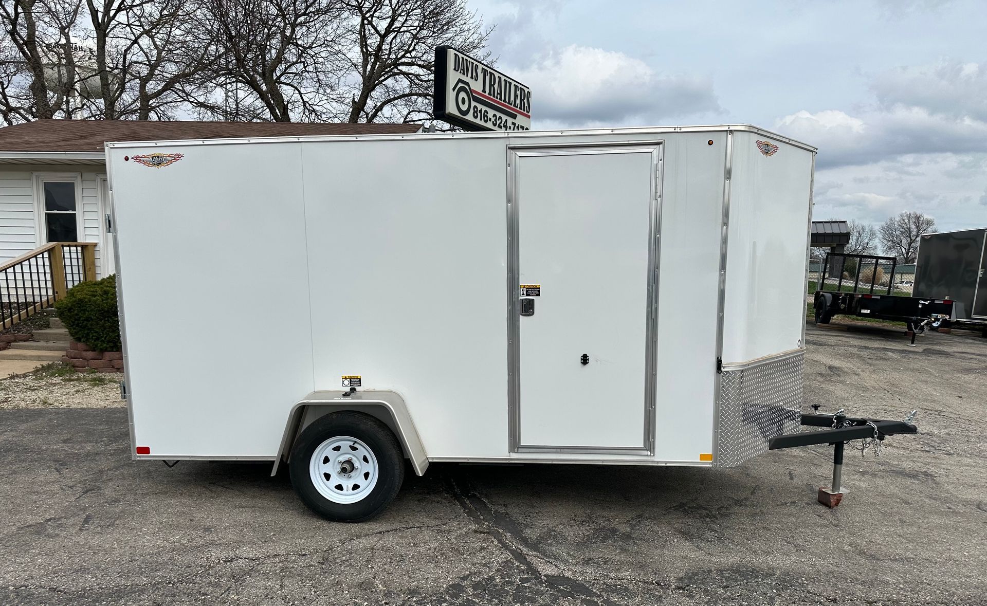 A black and silver trailer is parked on the side of the road.
