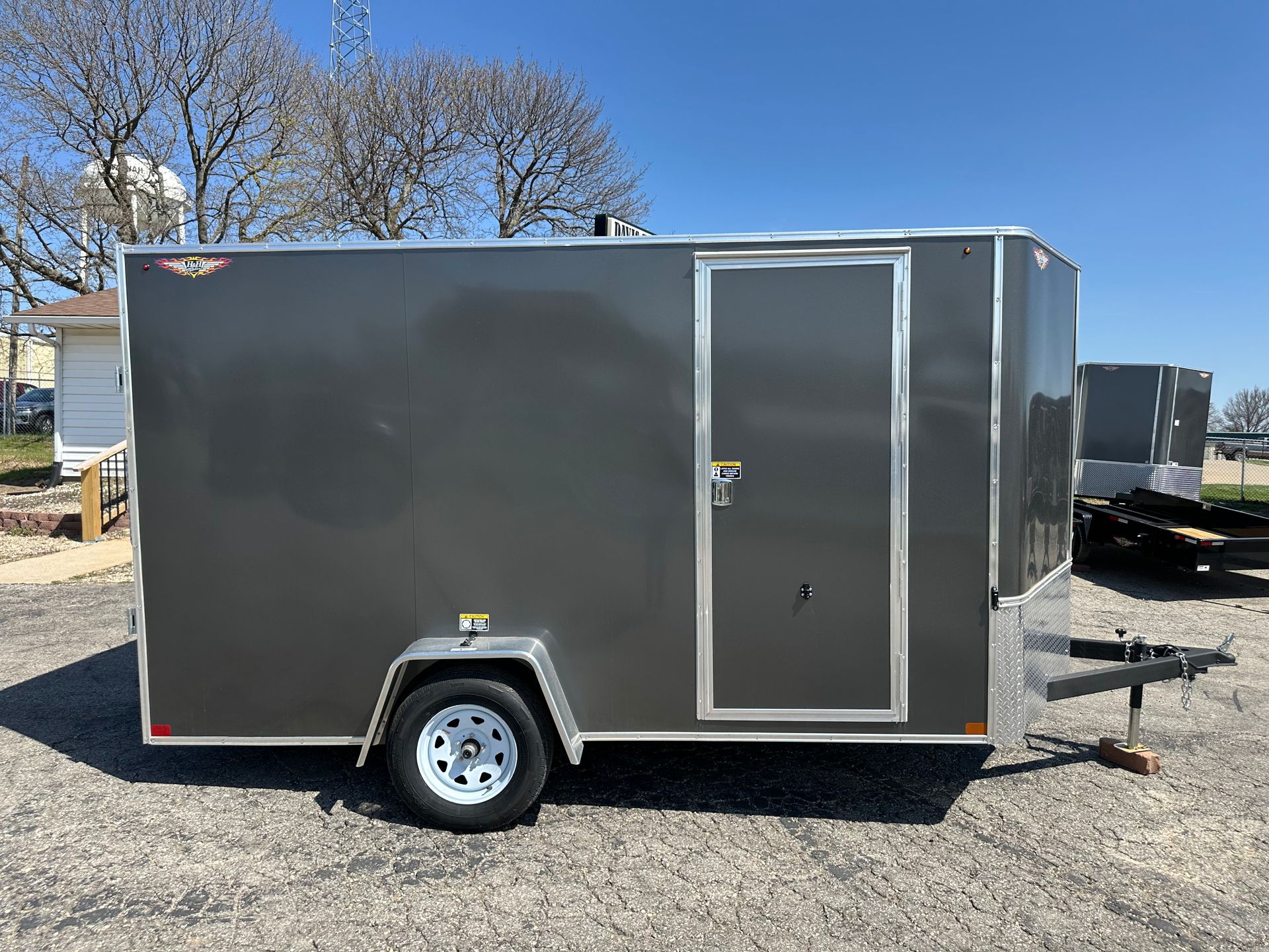 A white trailer is parked on the side of the road.