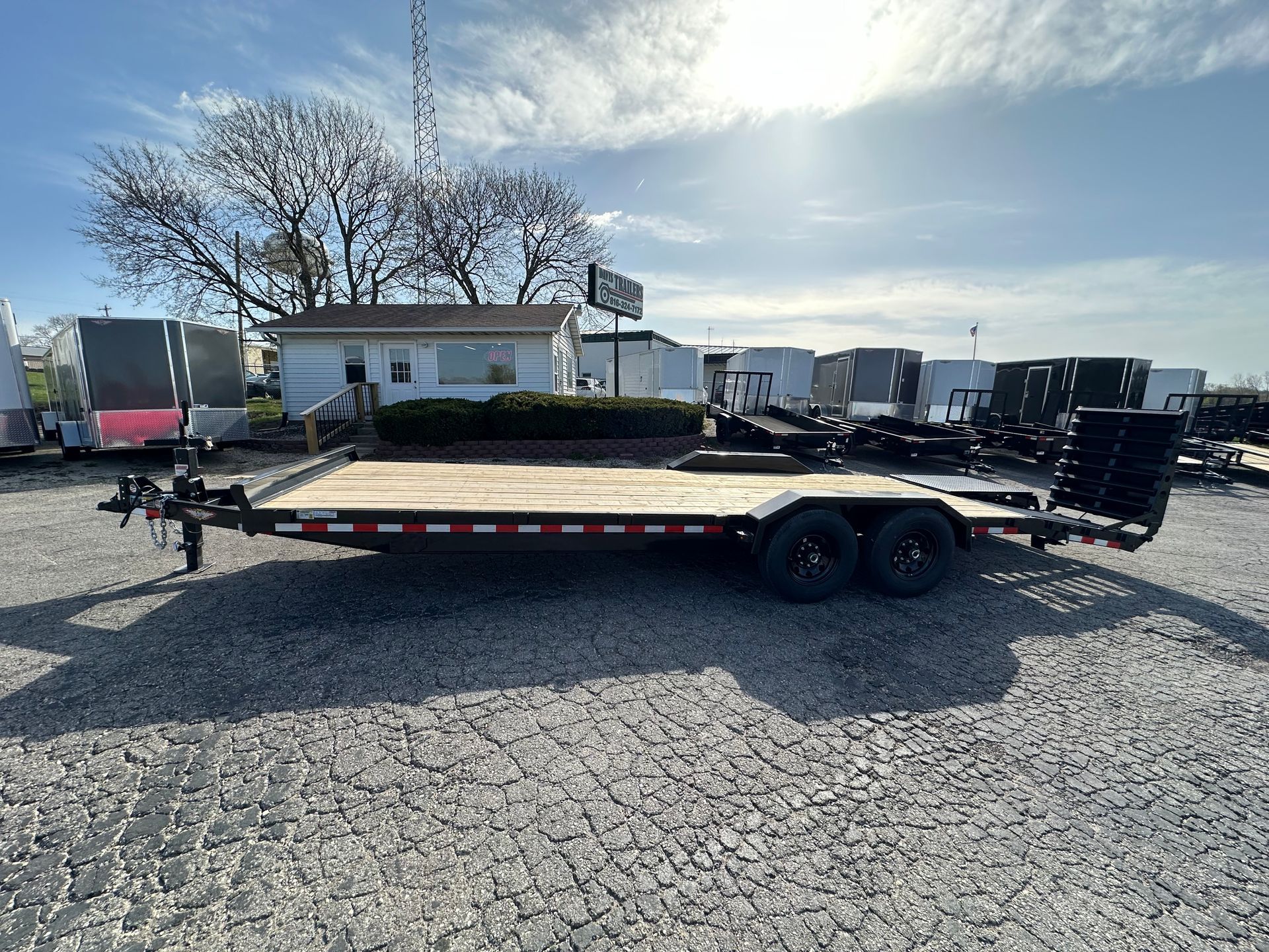 A trailer is parked on gravel in a parking lot.
