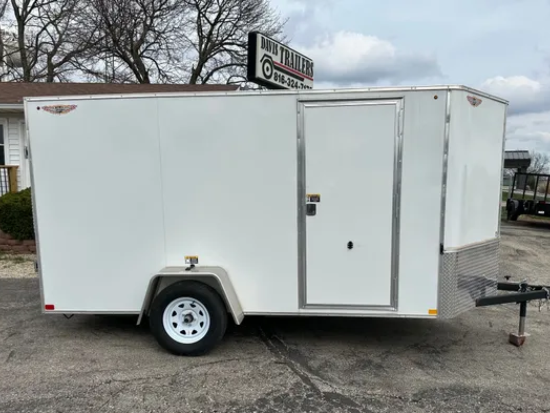 A white trailer is parked on the side of the road.