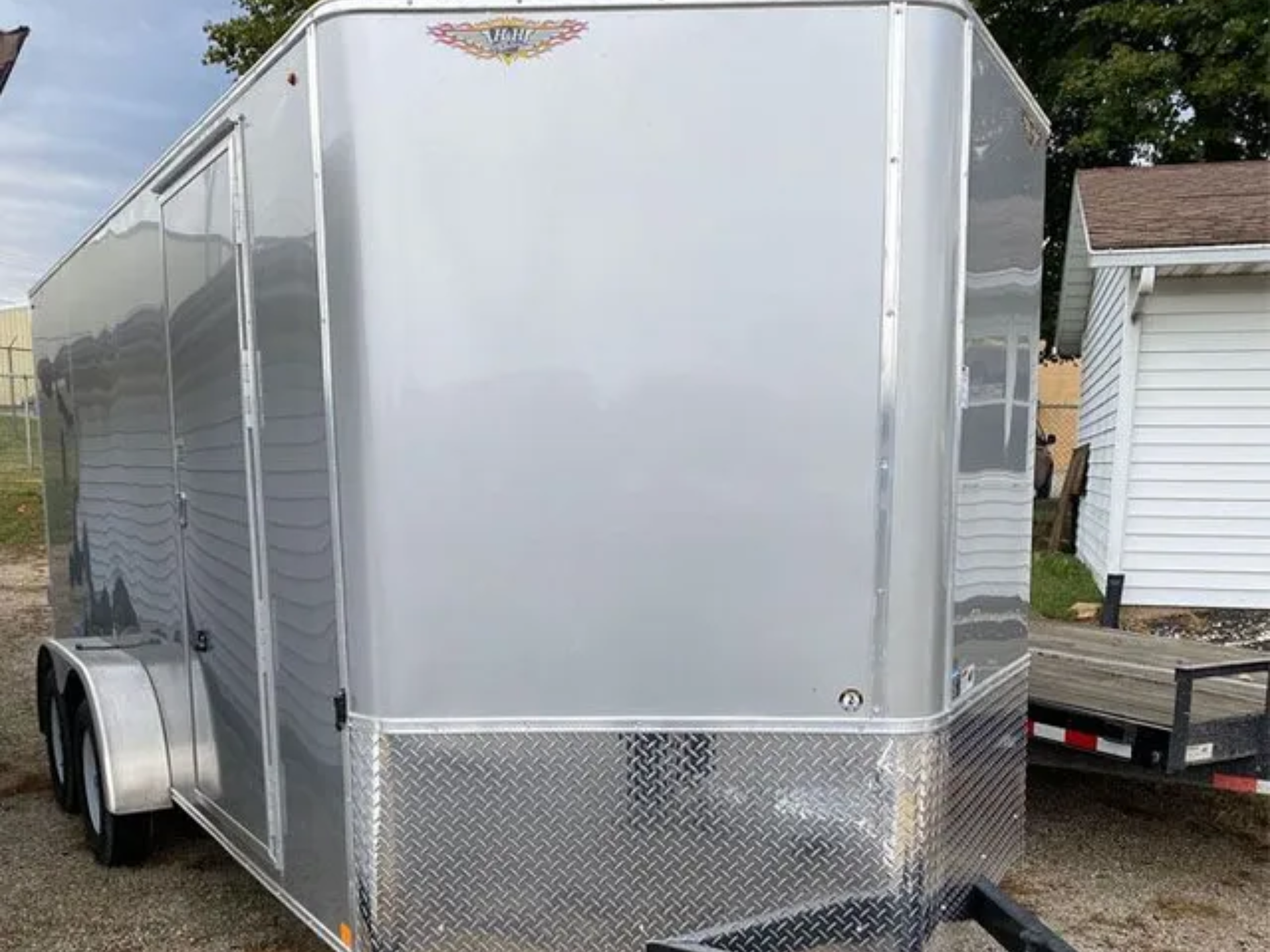 A trailer is parked in a gravel lot in a road.