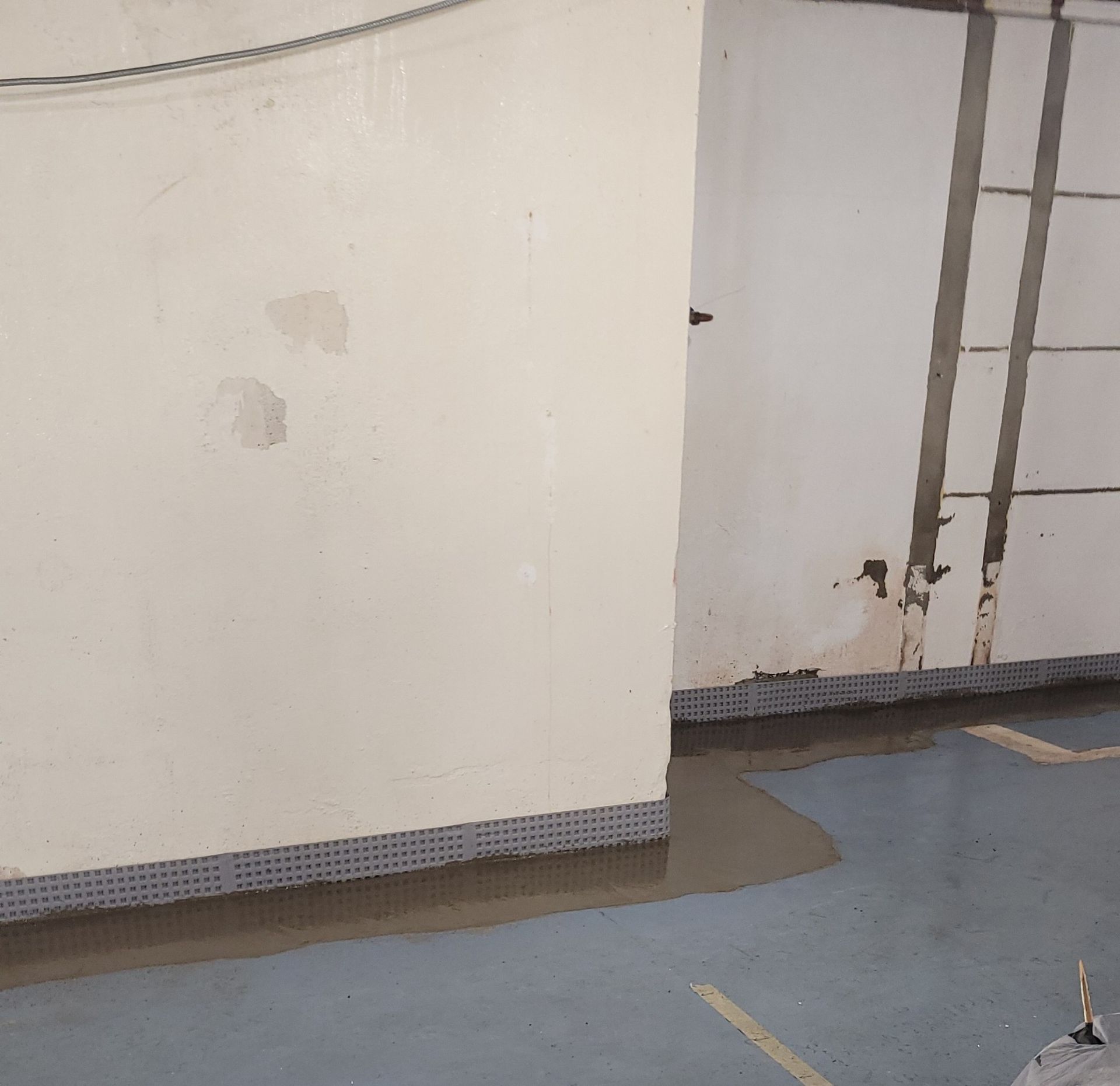 A room with a white wall and a blue floor