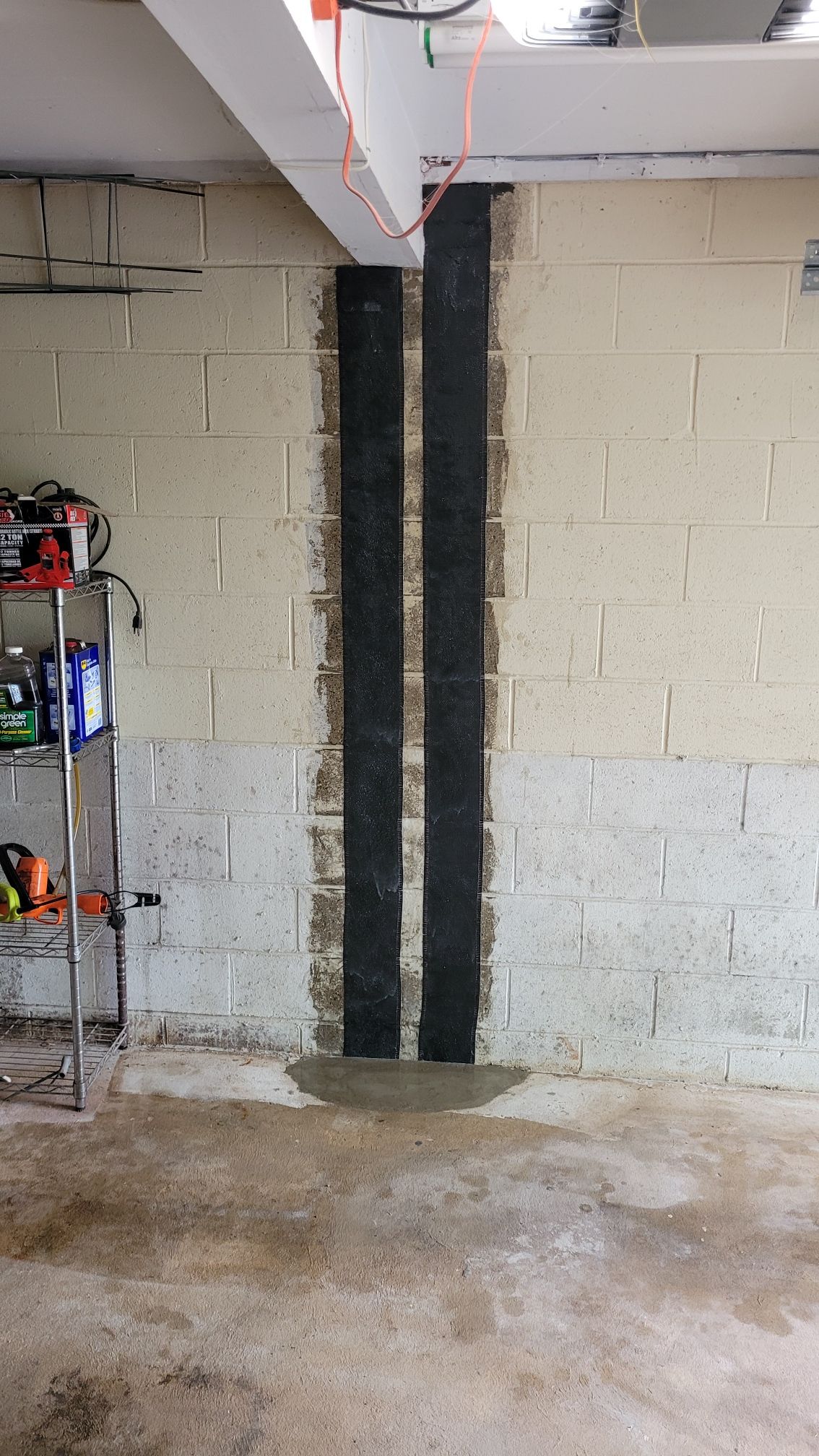 A garage with a brick wall and a concrete floor.