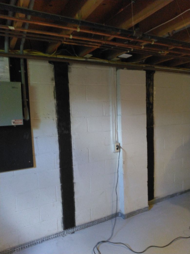 A basement with white walls and a wooden ceiling