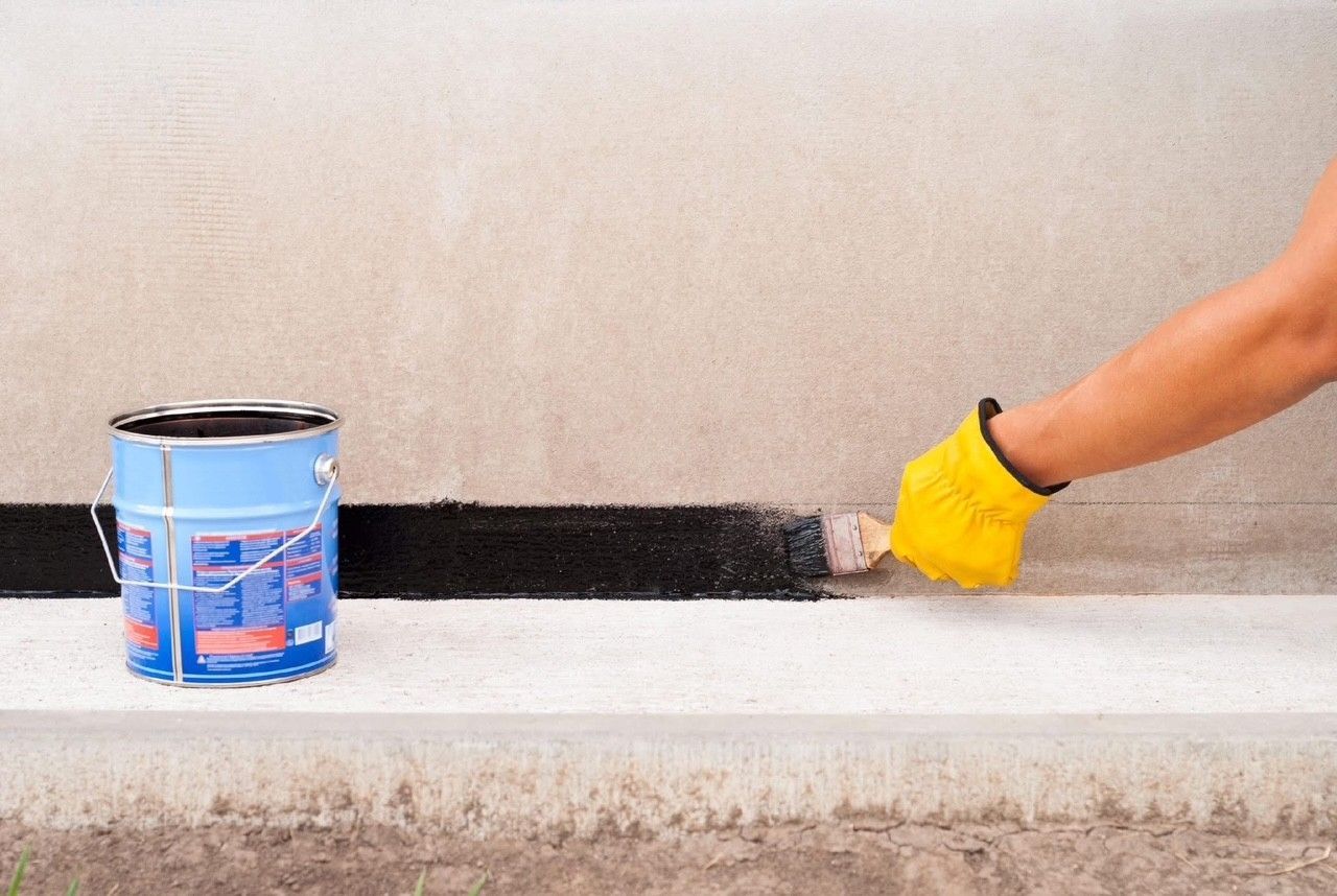 A person is painting a wall with a brush.