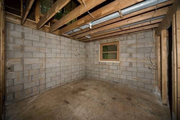 An empty basement with brick walls and a window.