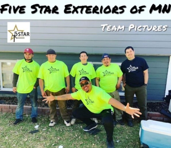A group of men wearing neon green shirts are posing in front of a house