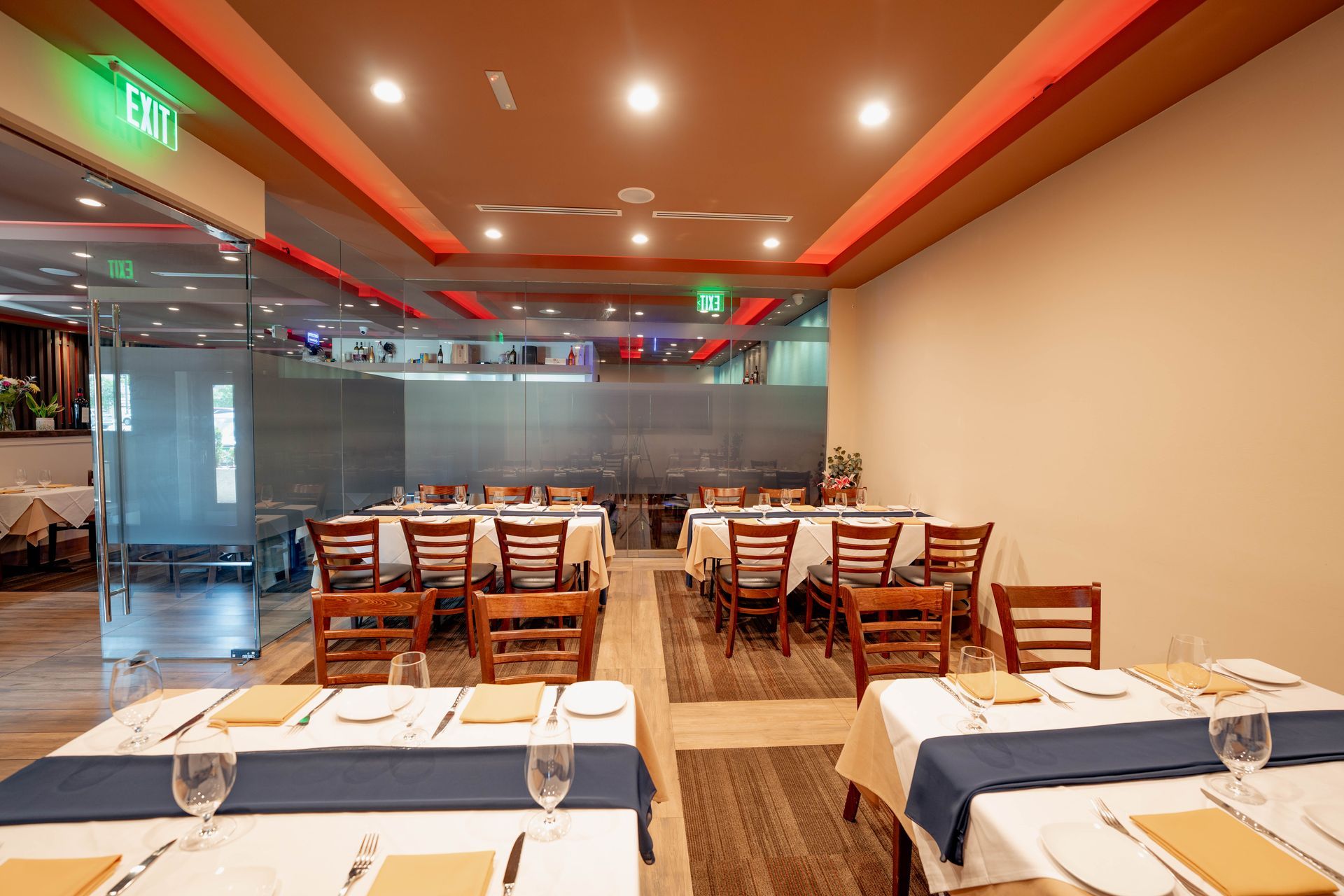 Restaurant interior with tables set for dining, featuring a modern design with red and orange lighting.