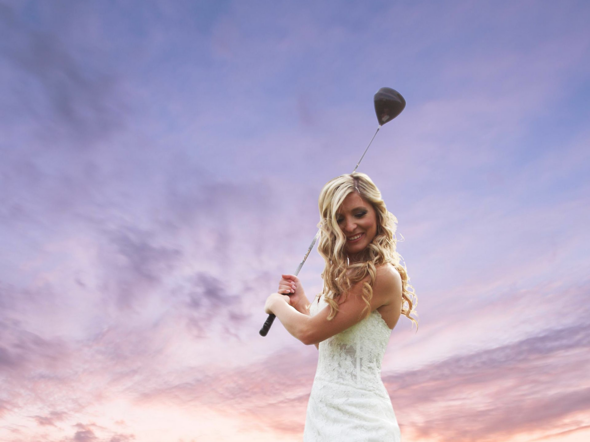Playful golf themed wedding portrait of bride and groom on the green.