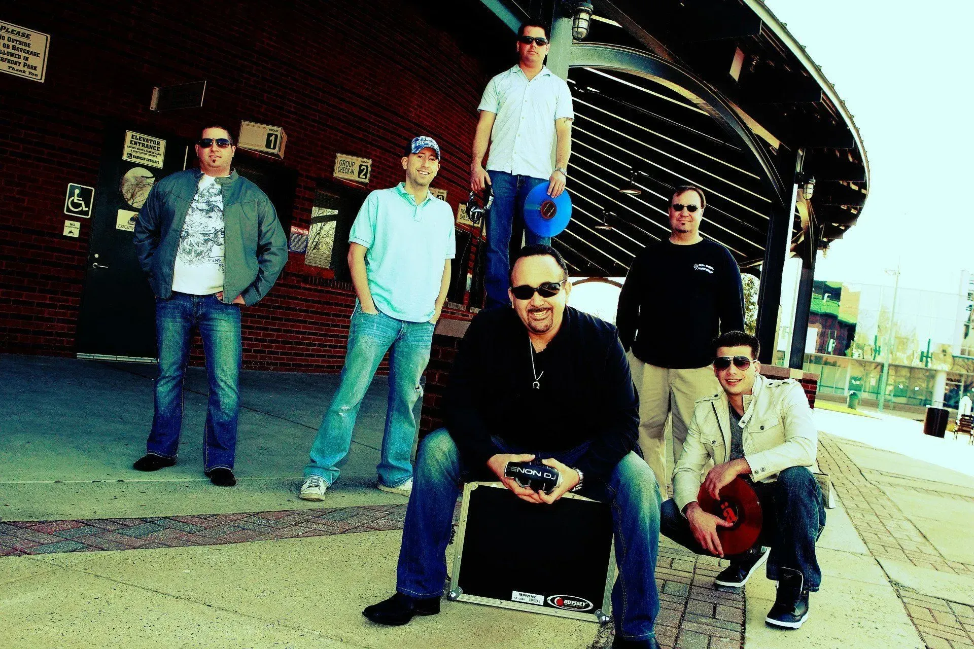 Police officer in uniform, smiling in front of an American flag and a dark backdrop.