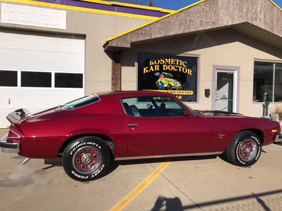 Red classic Camaro parked in front of the 