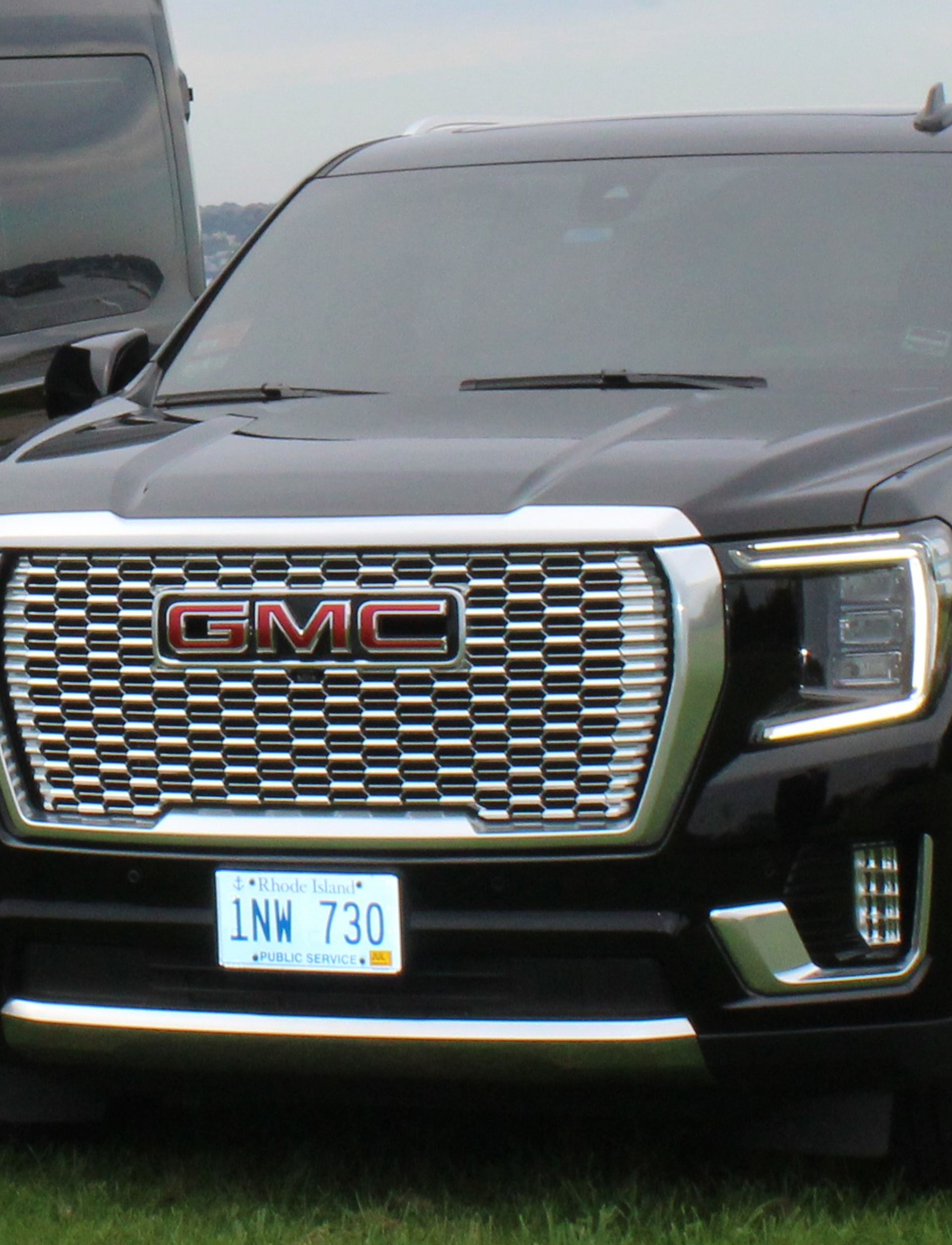 A black gmc truck is parked in the grass