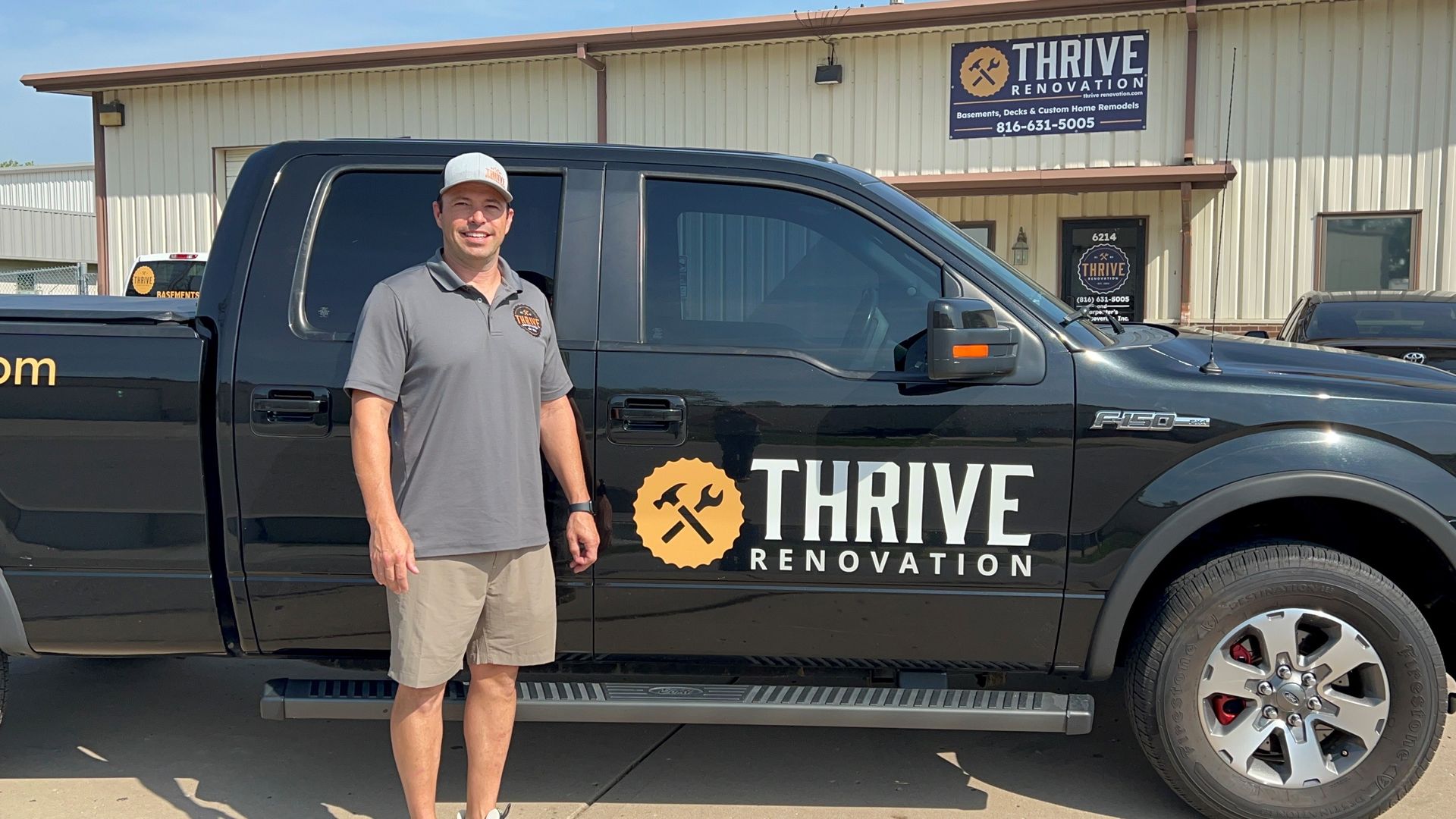 A man is standing in front of a thrive renovation truck.
