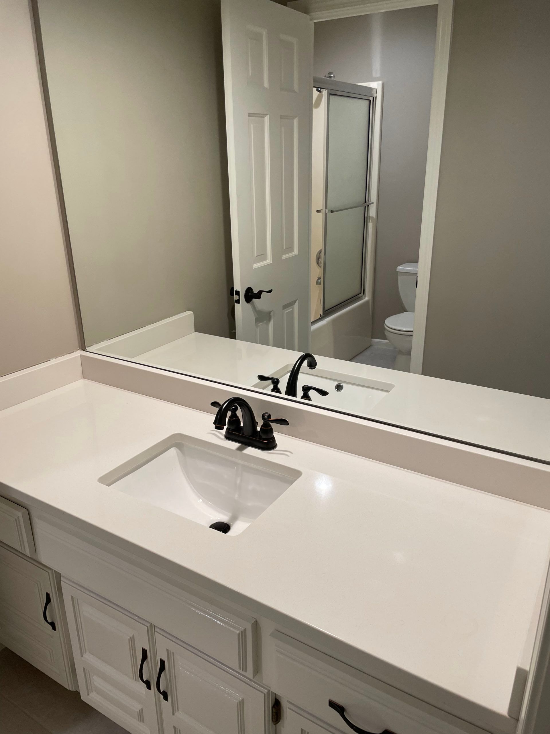 A bathroom with a sink , mirror and toilet.