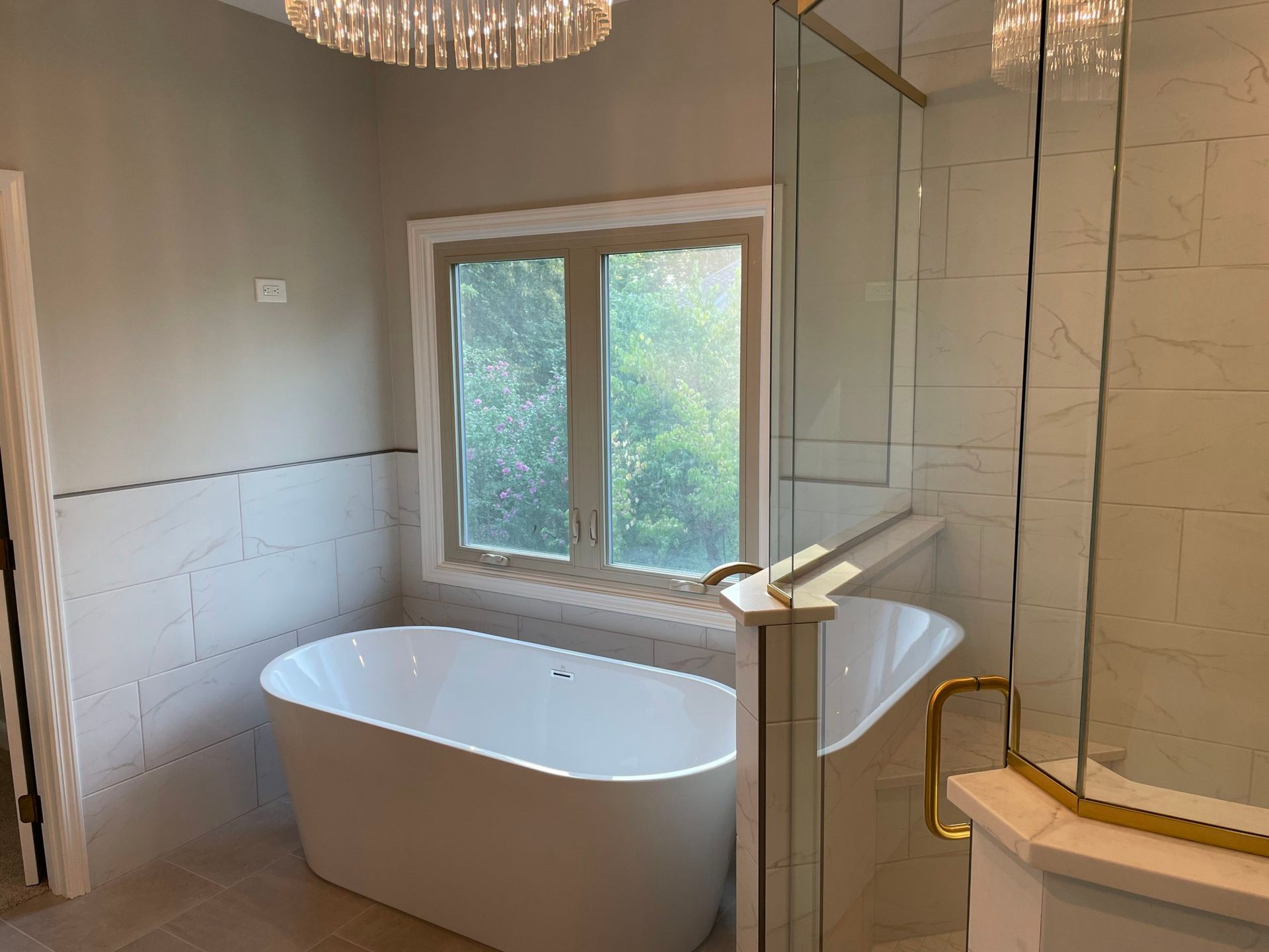 A bathroom with a tub , shower and window.