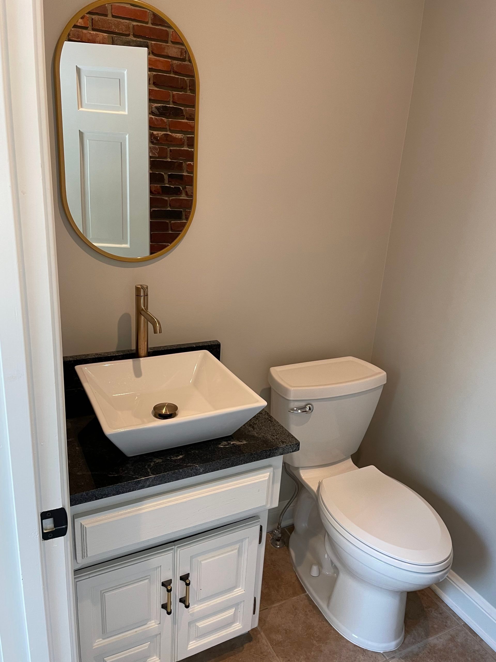A bathroom with a sink , toilet and mirror.