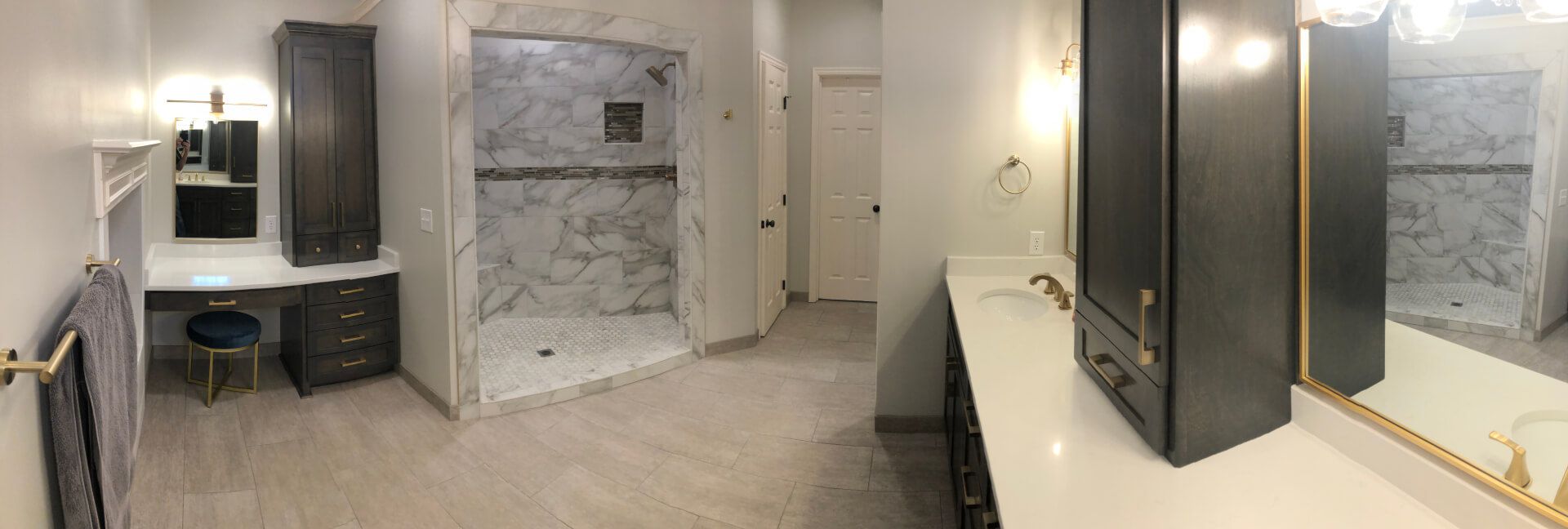 A bathroom with a walk in shower , sink , mirror and vanity.