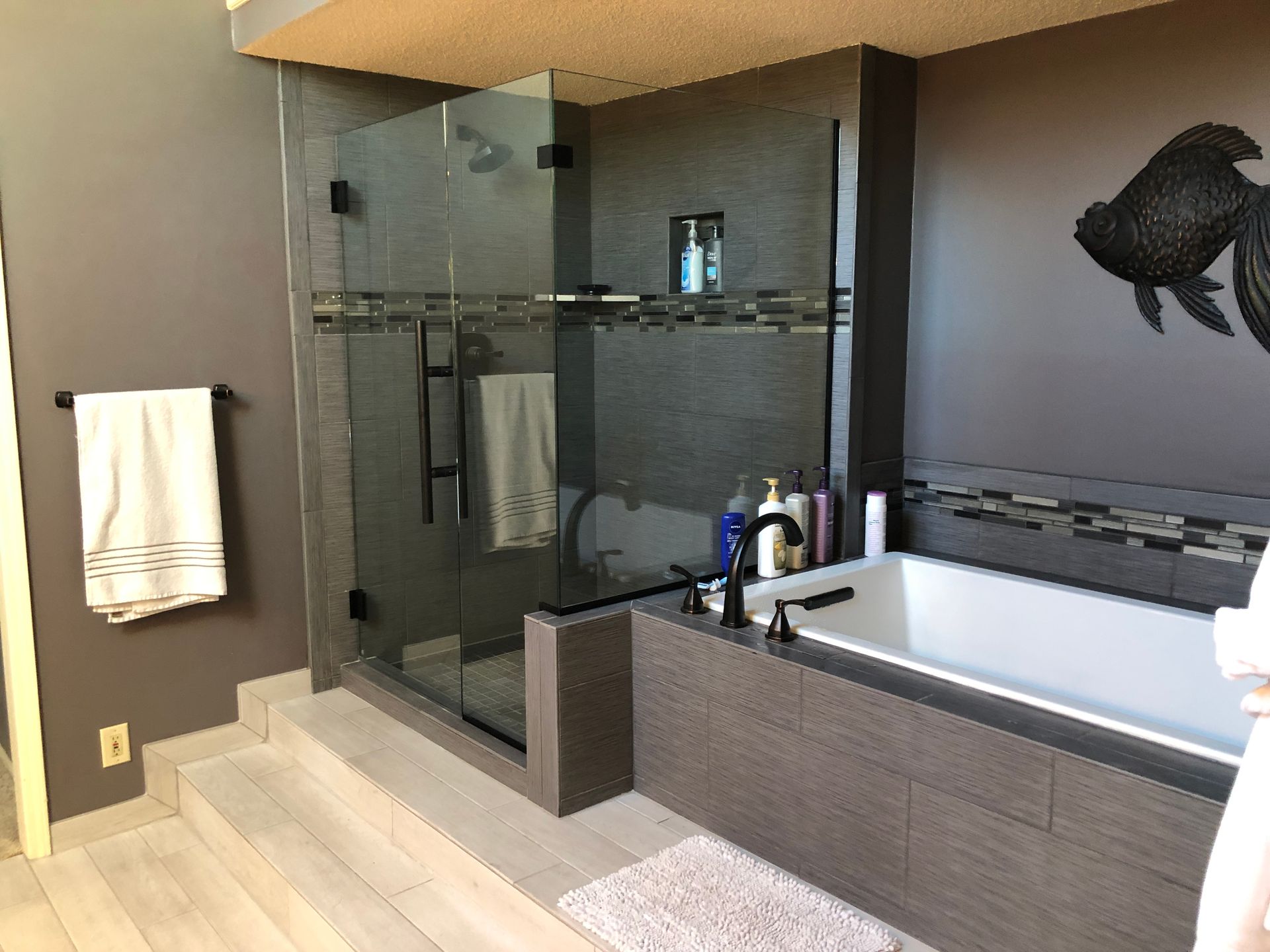 A bathroom with a bathtub and a walk in shower.