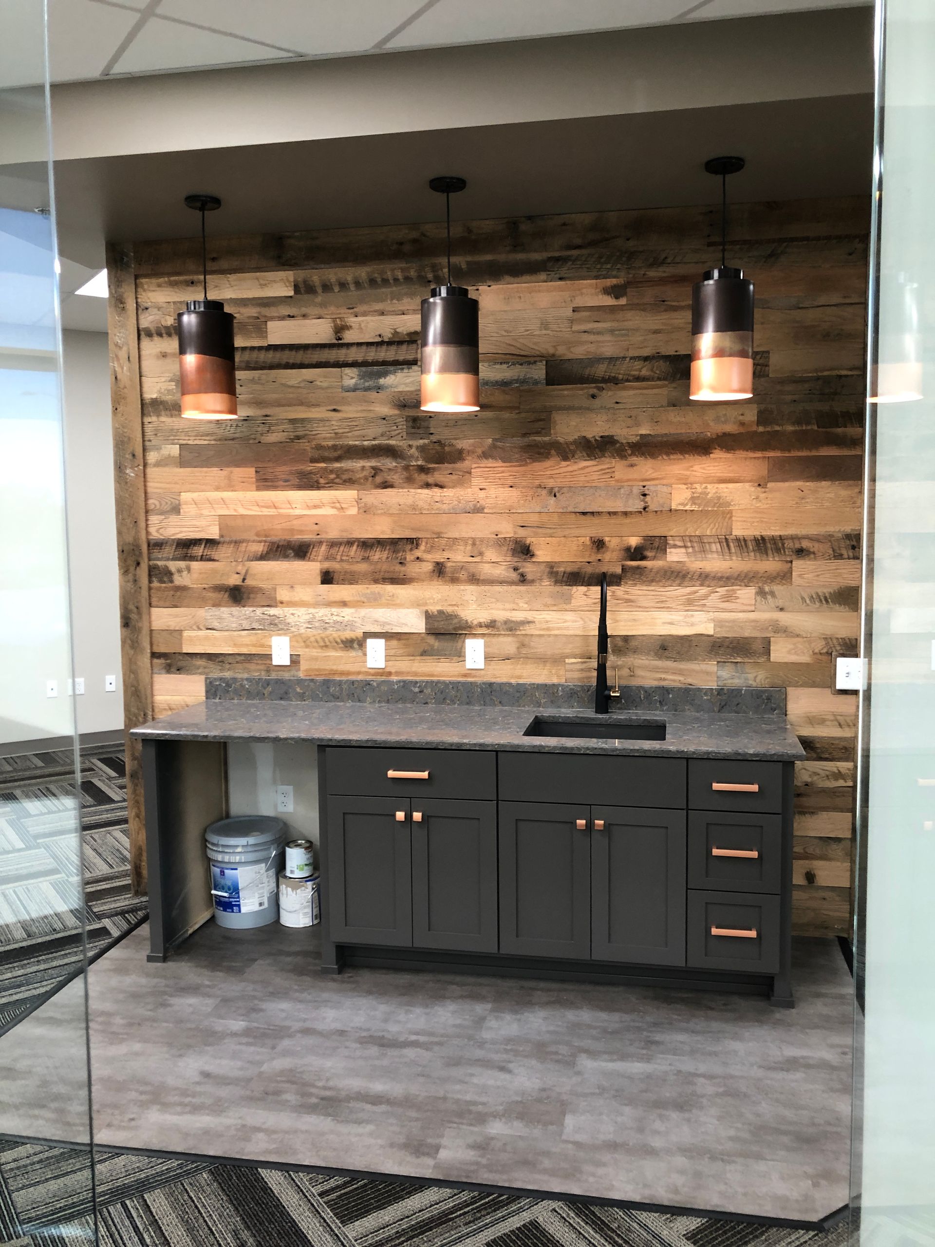 A kitchen with a wooden wall and a sink