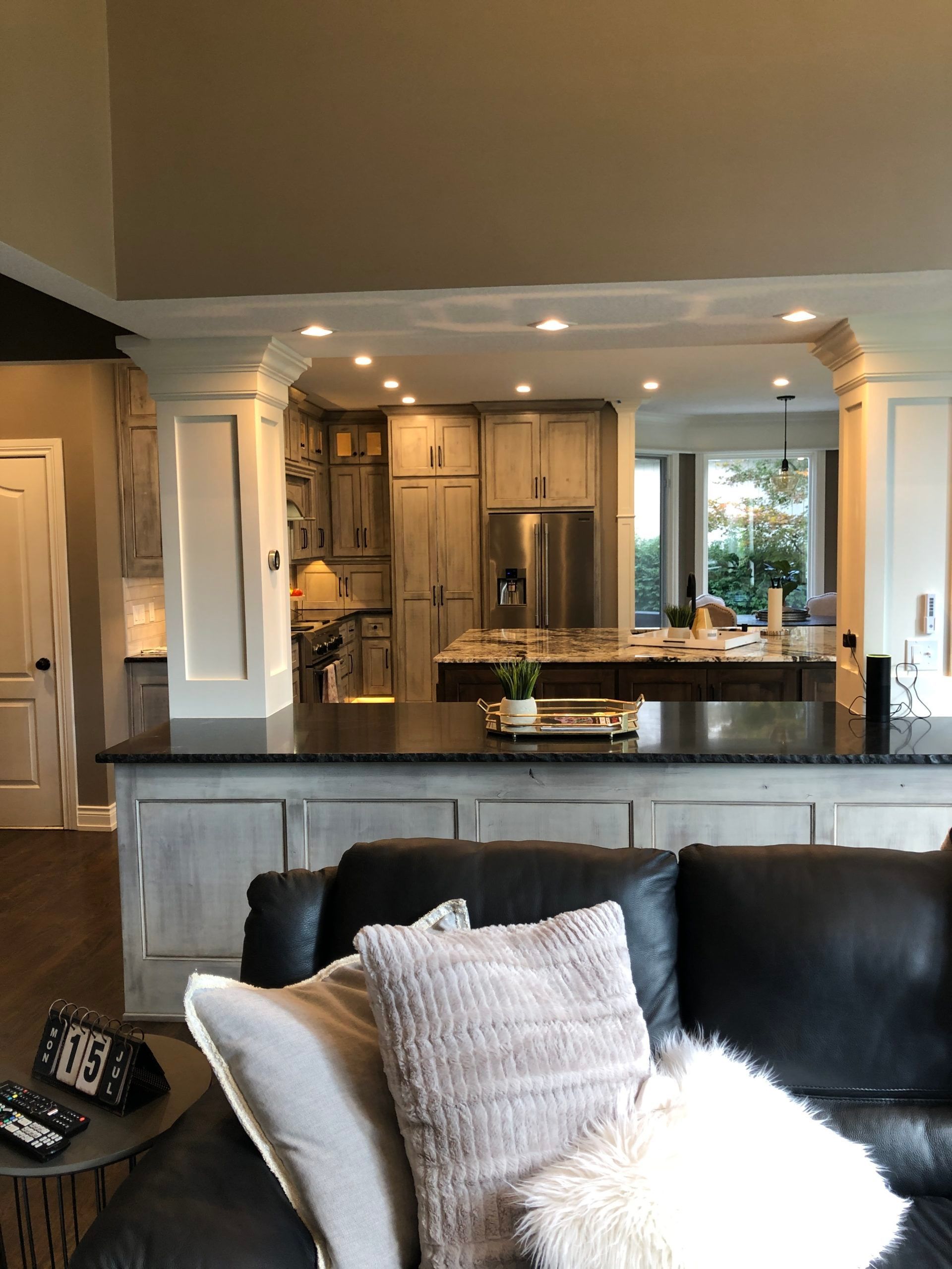 A living room with a couch and a kitchen in the background