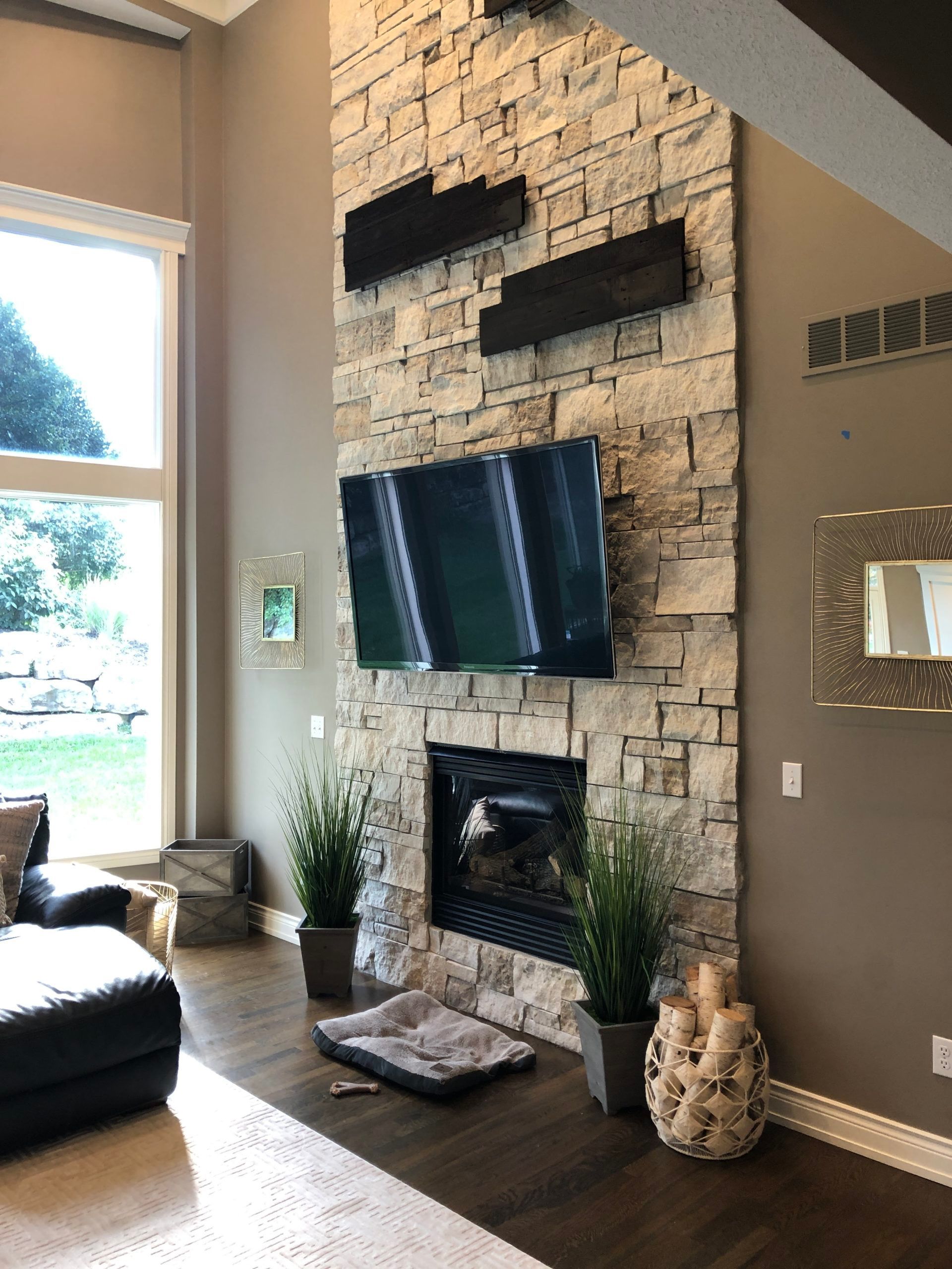 A living room with a fireplace and a flat screen tv on the wall.