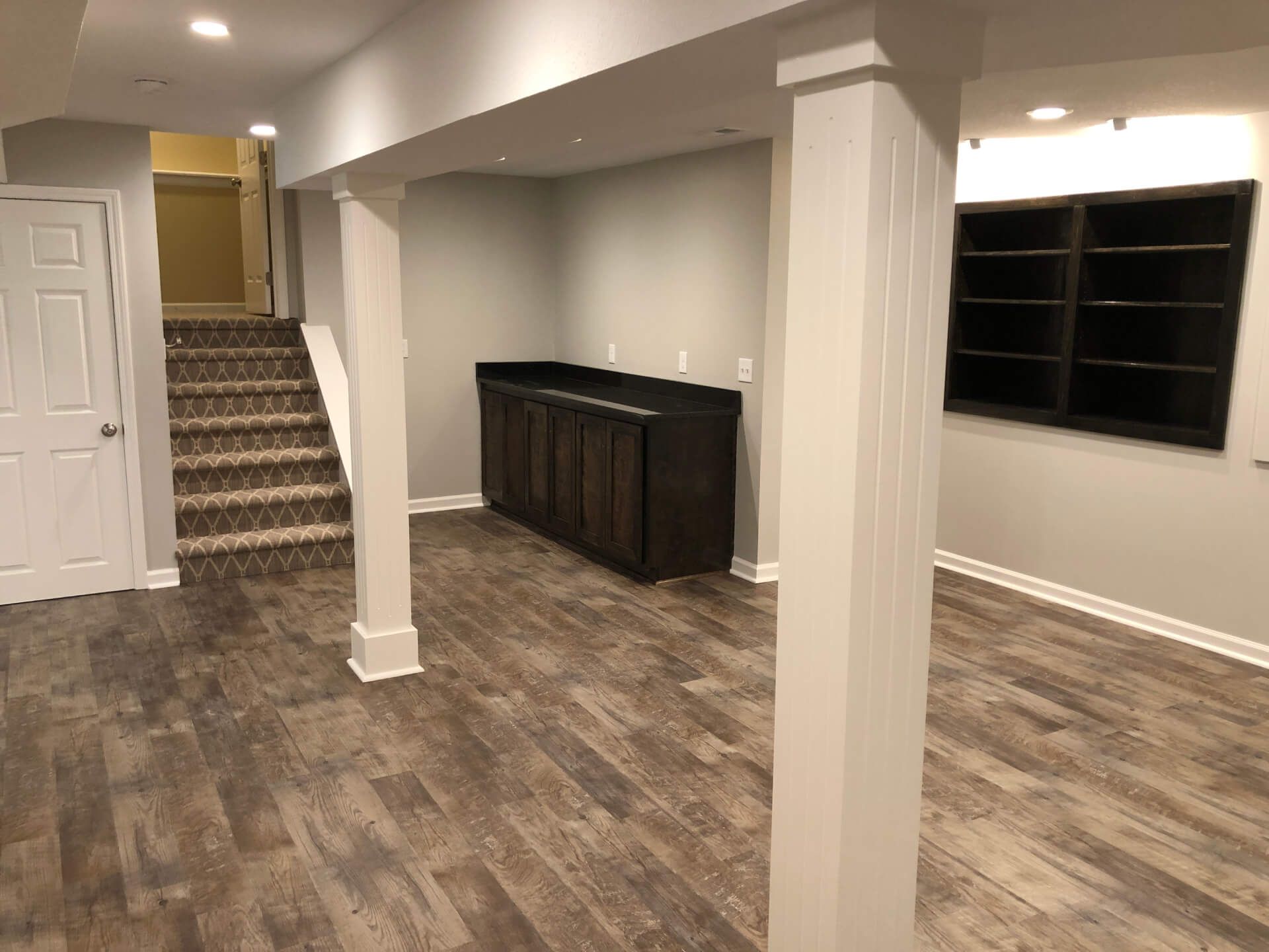 It is a basement with hardwood floors and stairs.