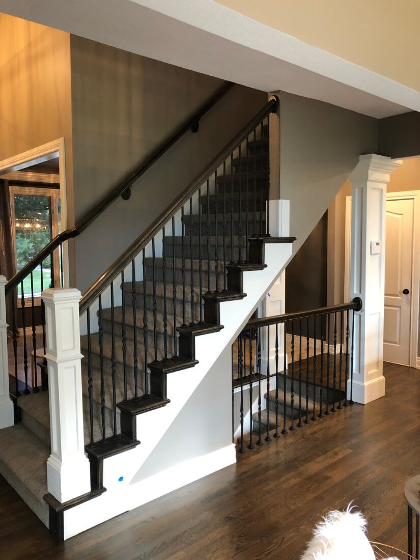 A staircase in a house with a dog in the background