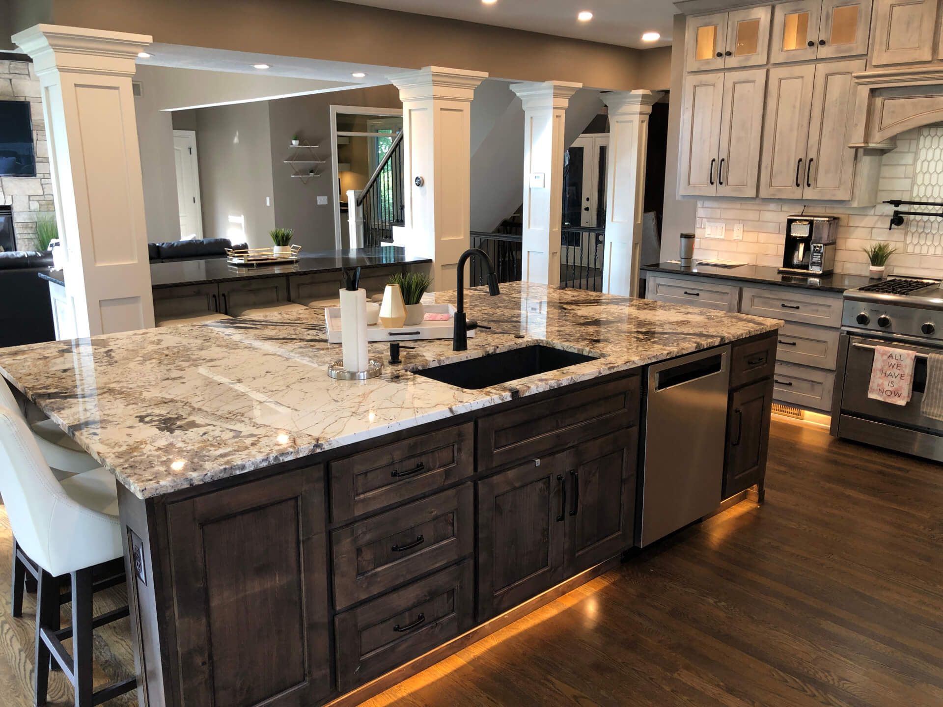 A kitchen with a large island and granite counter tops.