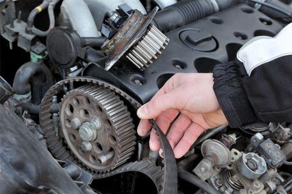 A person is cleaning a car engine with a brush