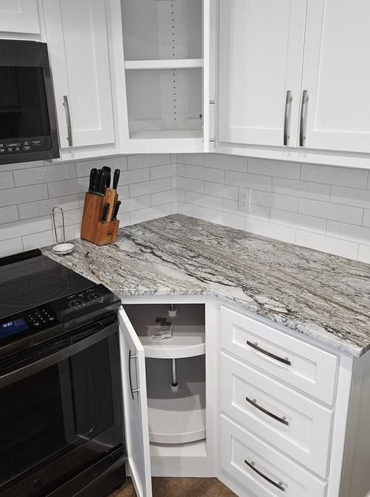 White kitchen with a corner countertop. A lazy susan is visible.