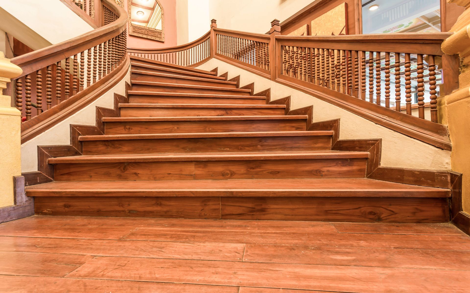 Wooden staircase with intricate railing detail, leading upwards.