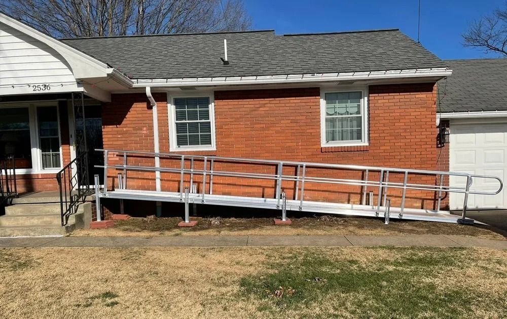 A red brick building with an aluminum wheelchair ramp for accessibility.