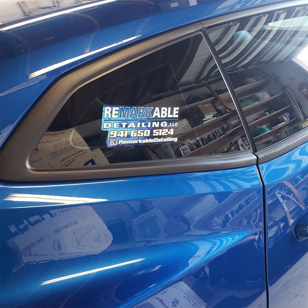 Blue car with window decal advertising 