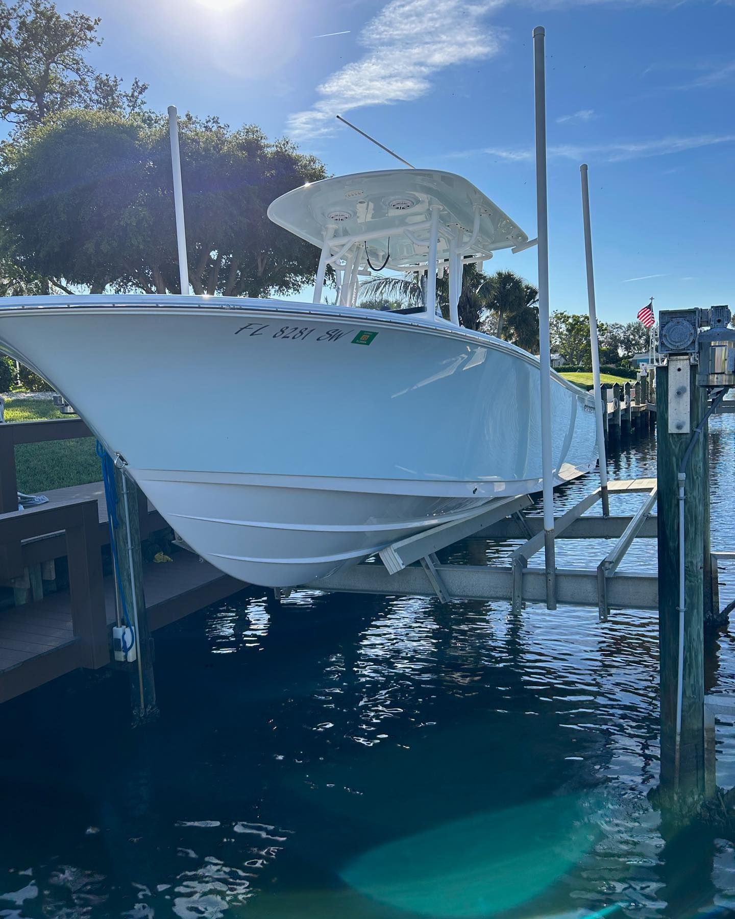 White boat on a lift over water; sunny day.