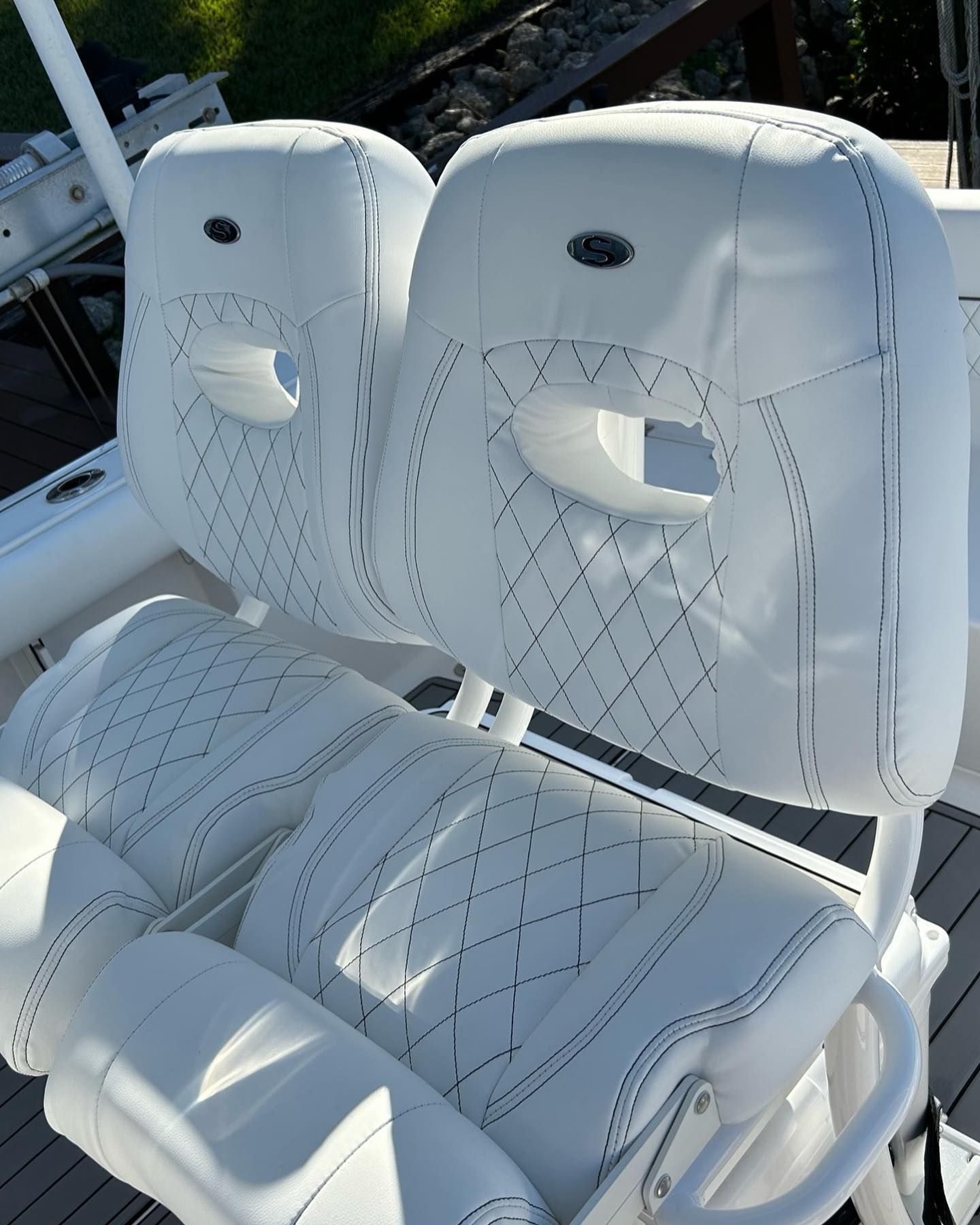 White boat seats with diamond stitching and headrests, set on a boat deck.