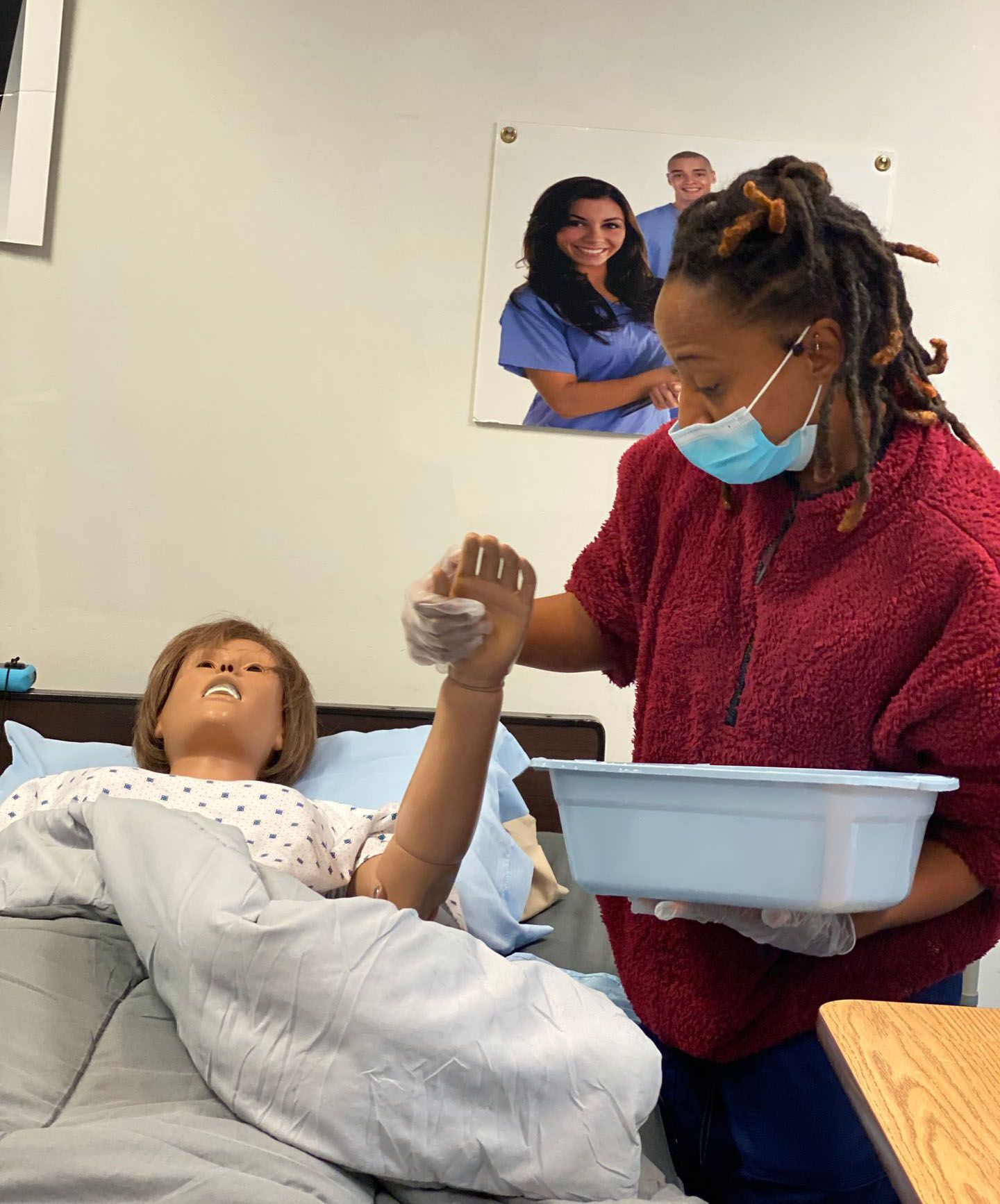 Health Professional Trainee holding the hand of a medical manikin