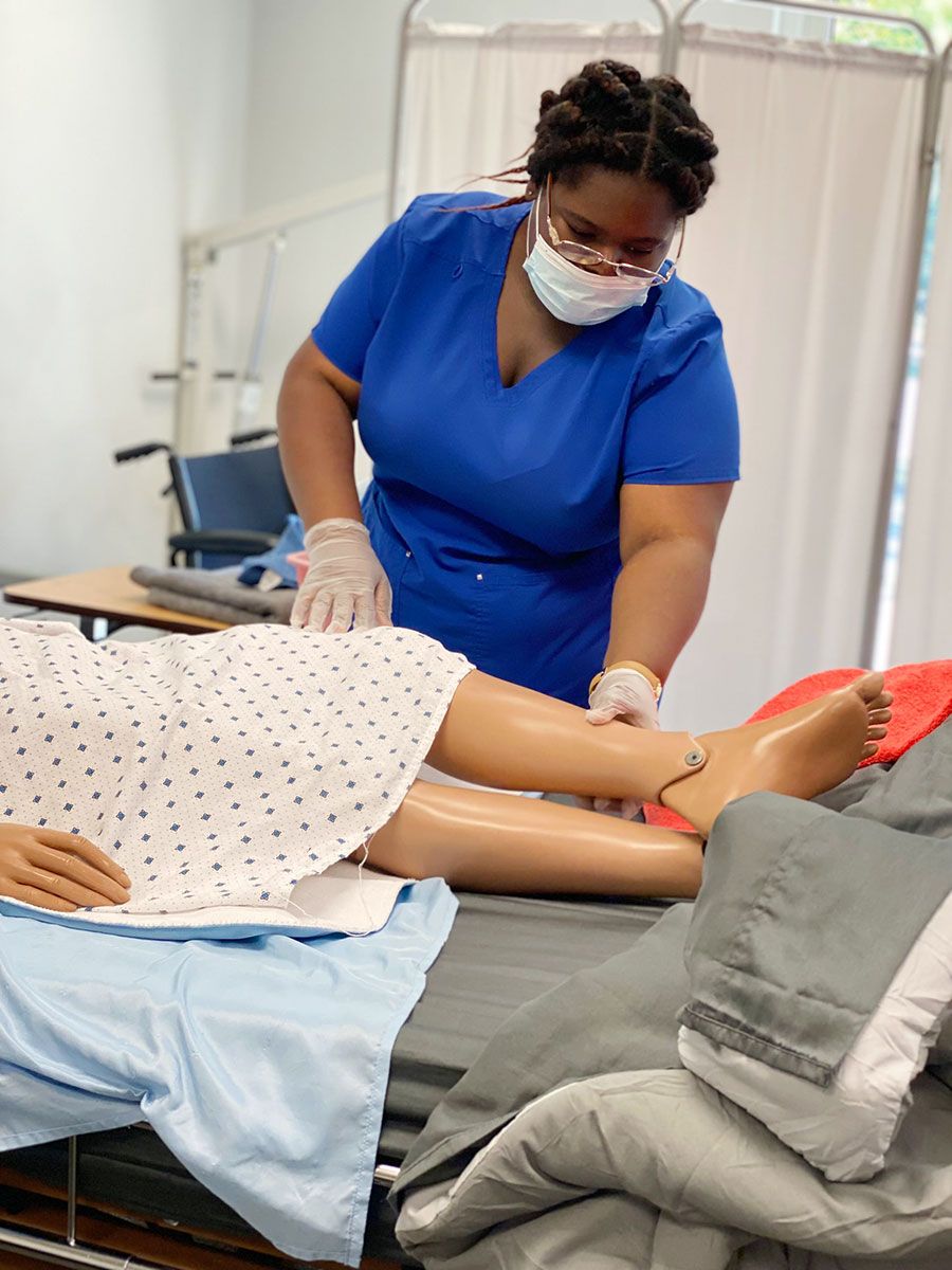 Health Professional Trainee examining the legs of a medical manikin
