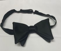 A black bow tie is sitting on a white surface