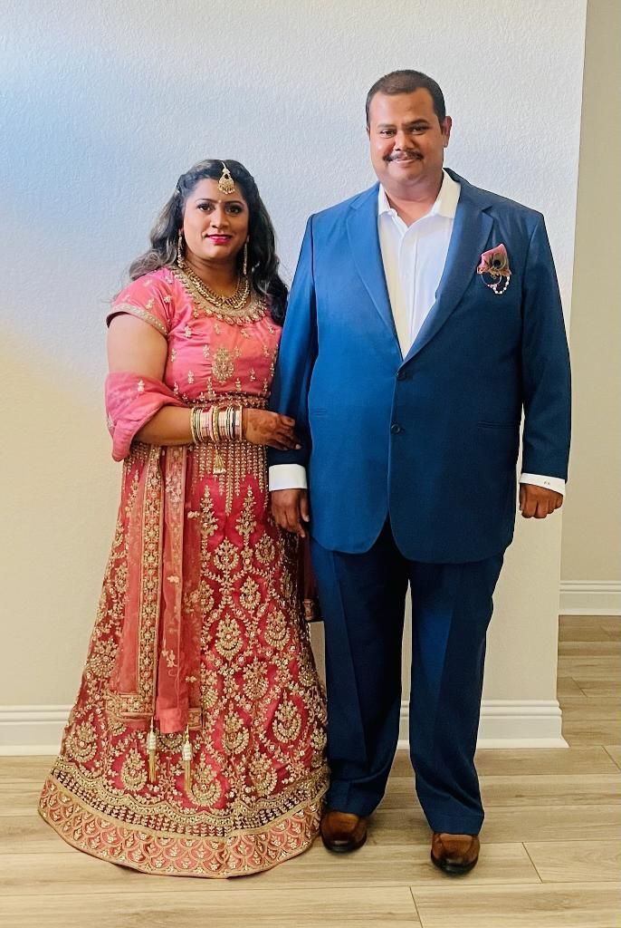 A wedding picture of man in a custom-tailored suit and a woman in a pink dress